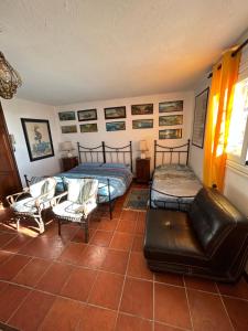 a bedroom with two beds and a couch and chairs at La Masa in Èze