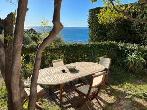 a wooden table and chairs with the ocean in the background at La Masa in Èze
