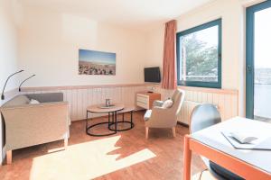 a hotel room with a waiting area with a table and chairs at Appartement Greenlön in Westerland