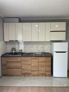 a kitchen with white cabinets and a white refrigerator at House in Mtskheta in Mtskheta