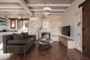 a living room with a couch and a fireplace at Viatzo Villas in Laganas