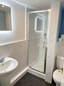 a bathroom with a shower and a sink and a toilet at Apartment with Swimming Pool in Tenby