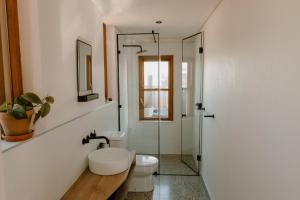 La salle de bains est pourvue de toilettes et d'une douche en verre. dans l'établissement Yzers Boat House, à Yzerfontein