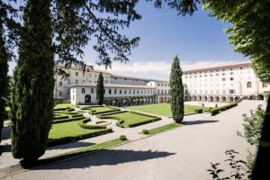 a large white building with trees and a courtyard at Studio Moderne, Terrasse et Parking in Romans-sur-Isère