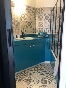 Baño azul con lavabo y espejo en Studio Moderne, Terrasse et Parking en Romans-sur-Isère