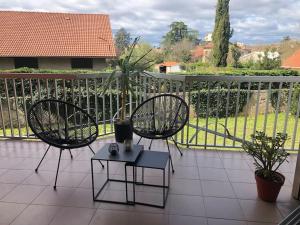 two chairs and a table on a balcony at Studio Moderne, Terrasse et Parking in Romans-sur-Isère +1 photo