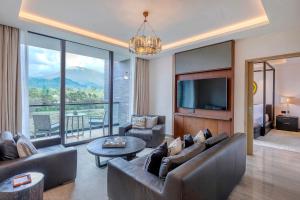 a living room with a couch and a tv and a table at Gran Melia Arusha in Arusha