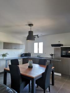 cocina con mesa de madera y sillas en Le Circuit du Soleil, en Lédenon