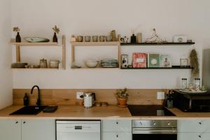 a kitchen with wooden counter tops and shelves at Yzers Boat House in Yzerfontein
