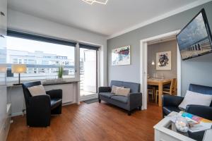 a living room with a couch and chairs and a table at Strandgeflüster in Westerland (Sylt)