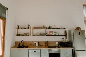 a kitchen with white cabinets and a refrigerator at Yzers Boat House in Yzerfontein