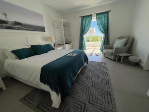 a bedroom with a bed and a chair and a window at West Coast Shores in Jacobs Bay