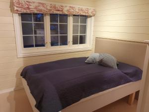 Bett in einem Schlafzimmer mit Fenster in der Unterkunft Smørøyet. Sentral beliggenhet på Geilo. in Geilo