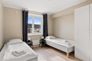 1 dormitorio con 2 camas y ventana en Forenom Serviced Apartments Bergen Skottegaten, en Bergen