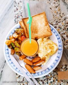 einen Teller mit Frühstücksfutter mit Toast und einem Getränk in der Unterkunft Hotel National Park- A Peaceful Family Home in Sauraha in Chitwan