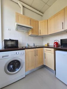 a kitchen with a washing machine and a microwave at Charmant studio Palais du Golf in Sospel