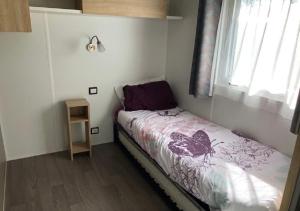 a small bedroom with a bed and a window at Mobilhome COSY - espace aquatique - lac in Gastes