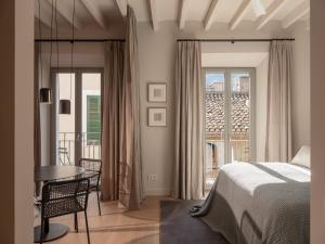 1 dormitorio con cama, mesa y balcón en Can Verí Suites en Sóller