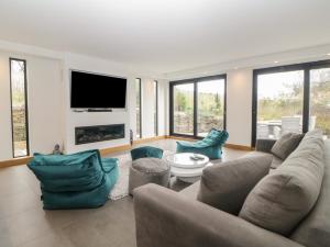 a living room with a couch and chairs and a tv at 2 White Rock Court in Paignton