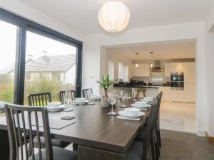 a dining room with a large wooden table and chairs at 2 White Rock Court in Paignton