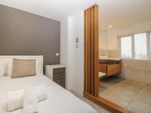 a bedroom with a bed and a sink and a mirror at 2 White Rock Court in Paignton