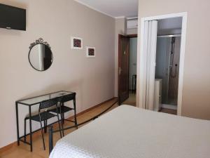 1 dormitorio con cama, espejo y mesa en Villa Eleila Affittacamere, en Terracina