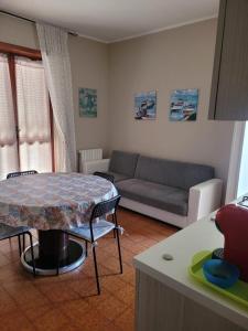 sala de estar con mesa y sofá en Villa Eleila Affittacamere, en Terracina