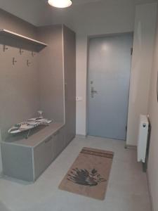 een badkamer met een witte deur en een kleed en een deur bij Izo's Home in Koetaisi