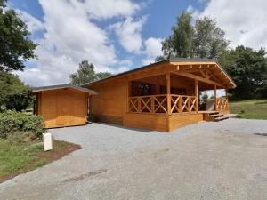 un gran edificio de madera con garaje en Chalet "L'aventure" calme et verdoyant - 6 pers, en Sulniac