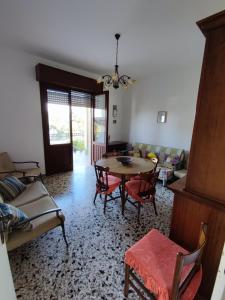 Duca's Home في مارينا بورتو: غرفة معيشة مع طاولة وكراسي