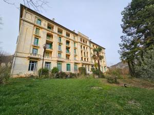 a large building with a grass field in front of it at Charmant studio Palais du Golf in Sospel