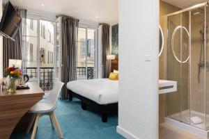 a hotel room with a bed and a bathroom at Hotel Khla Nice in Nice