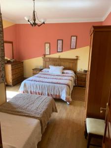 um quarto com 2 camas e paredes vermelhas em Casa rural Villa Abeleste em Fuentelisendo