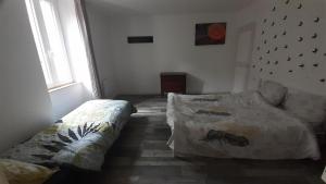 a bedroom with two beds and a window at Appartemment situé a lacaune les bains in Lacaune +17 photos