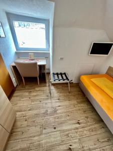 a room with a bed and a sink and a table at Hotel-Heilsberg in Gottmadingen