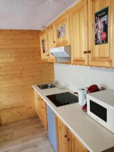 una cucina con mobili in legno e un piano di lavoro di Maison vue Montagne avec jardin a Oz Altre 14 foto
