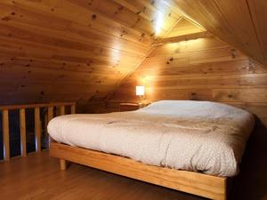 una camera con un letto in una baita di tronchi di Maison vue Montagne avec jardin a Oz