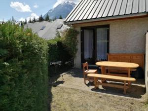 un tavolo da picnic e una panca di fronte a una casa di Maison vue Montagne avec jardin a Oz