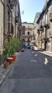 an empty street with potted plants and buildings at Casetta Verga Loft in Catania