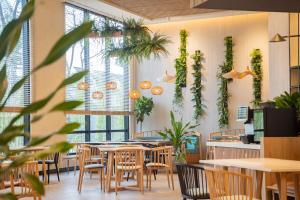 a restaurant with tables and chairs and plants on the wall at Melia Hanoi in Hanoi