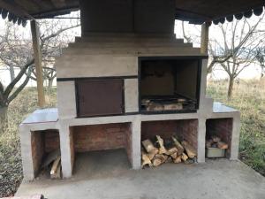 an outdoor oven with a pile of fire wood at Countryside Home 