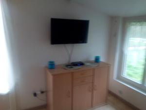 Habitación con TV en la pared y armario. en Pis-en-lits en Viré