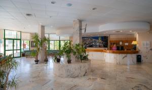 a lobby with potted plants in a building at Medplaya Hotel Pino Alto in Miami Platja