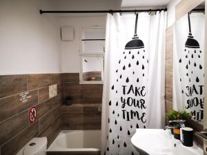 uma casa de banho com uma cortina de chuveiro que diz para ter o seu tempo em Sea&Sun Glyfada Apartment em Atenas