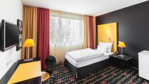 une chambre d'hôtel avec un lit et une télévision dans l'établissement Holiday Inn Munich - Westpark, an IHG Hotel, à Munich