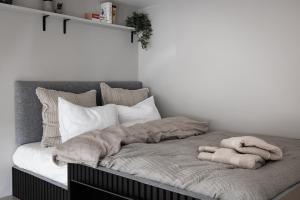 a bed with a blanket and pillows on it at Peaceful Scandinavian Studio - 19mins from City Centre in Stockholm