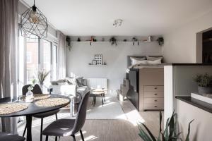 uma sala de estar com uma mesa e cadeiras e um sofá em Peaceful Scandinavian Studio - 19mins from City Centre em Estocolmo
