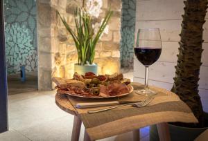 un plato de comida y una copa de vino en una mesa en Il Giardino degli Angeli, en Rivotorto