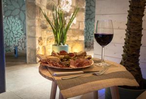 a plate of food and a glass of wine on a table at Il Giardino degli Angeli in Rivotorto 