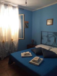 ein blaues Schlafzimmer mit einem Bett mit zwei Handtüchern darauf in der Unterkunft Villetta Torre Salsa in Siculiana